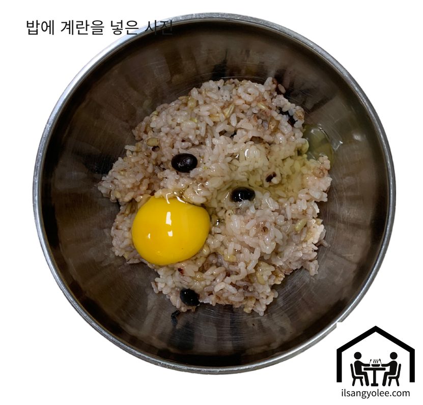 밥알 코팅을 위한 찬밥 위에 깨뜨려 넣은 계란